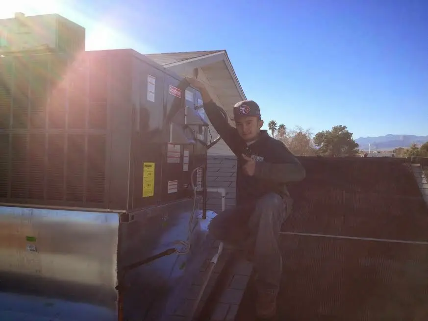 HVAC technician performing Heat Pump Repair on a rooftop unit in Pontiac